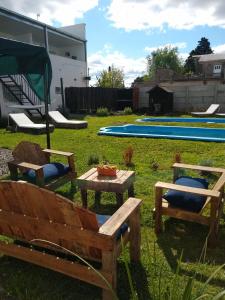 a yard with two benches and a table and a pool at Family place in Luján