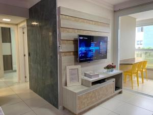  Il comprend un salon doté d'une télévision murale à écran plat. dans l'établissement Apartamento de frente para Piscina, com vista para o mar, à Florianópolis