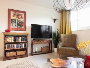 a living room with a television and a chair at Charming WILHELM in Saarbrücken