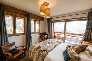 a bedroom with a bed and a large window at Chalet La Perle de L'Oisans - Appartements d'Exception in Vaujany