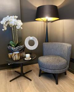 um quarto com uma cadeira e uma mesa com um candeeiro em The 0507 A Luxury Flat in Antwerp em Antuérpia
