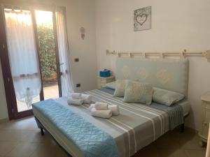 una camera da letto con un grande letto con asciugamani di La Casa azzurra a La Maddalena