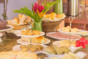 a table with plates of pastries and other foods at Pousada Villa do Sol in Itacaré