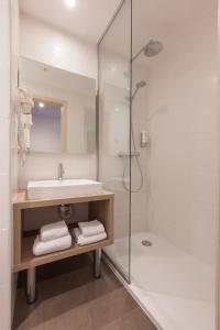 a white bathroom with a sink and a shower at Hotel Villa Royale in Brussels