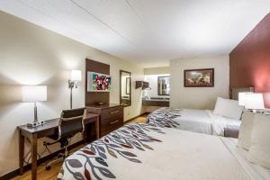 a hotel room with two beds and a desk at Red Roof Inn Saginaw – Frankenmuth in Saginaw +21 photos