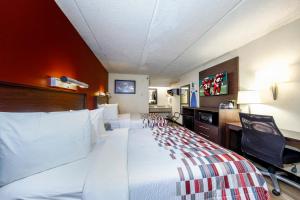 a hotel room with a large bed and a desk at Red Roof Inn Tampa - Brandon in Tampa