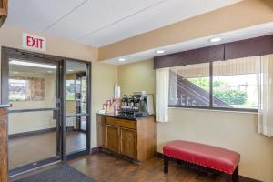 a waiting room with a red bench and a exit sign at Red Roof Inn Kalamazoo East – Expo Center in Kalamazoo