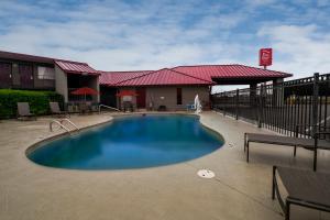 a large swimming pool in front of a building at Red Roof Inn Dothan in Dothan