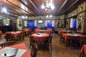 a restaurant with red tables and chairs in a room at Guesthouse Kastro in Edessa