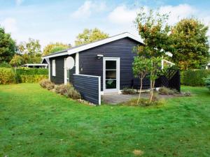 a small black house with a yard at 4 person holiday home in Hemmet in Hemmet