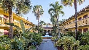 a courtyard of a building with a fountain and palm trees at Red Roof Inn Tampa Bay - St. Petersburg in St Petersburg