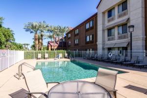 a swimming pool with chairs and a building at Red Roof Inn PLUS+ Tempe - Phoenix Airport in Tempe