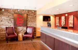 eine Bar in einem roten Gasthof mit zwei Stühlen in der Unterkunft Red Roof Inn Buffalo - Niagara Airport in Williamsville