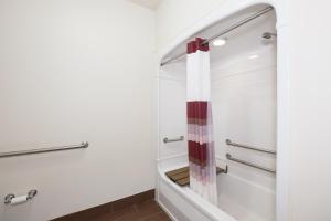 a bathroom with a shower with a red and white shower curtain at Red Roof Inn Jackson, OH in Jackson +21 photos