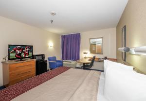 a hotel room with a bed and a flat screen tv at Red Roof Inn Jackson, OH in Jackson