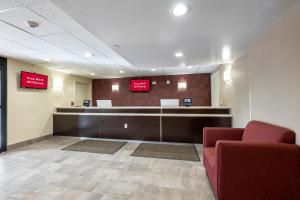 a lobby with a waiting room with a red couch at Red Roof Inn PLUS+ Tuscaloosa - University in Tuscaloosa