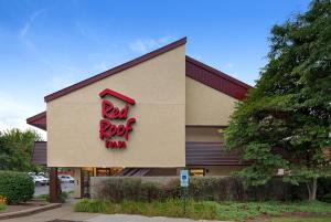 a building with a red rock sign on the side of it at Red Roof Inn Detroit-Rochester Hills/ Auburn Hills in Rochester Hills