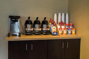 a counter top with a coffee maker and condiments at Red Roof Inn Detroit-Rochester Hills/ Auburn Hills in Rochester Hills