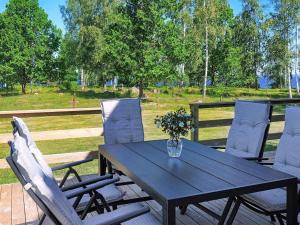 a black table and chairs with a vase of flowers at 14 person holiday home in HOVA in Hova