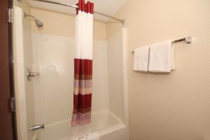 a bathroom with a shower with a red and white shower curtain at Red Roof Inn Gaffney in Gaffney +8 photos