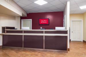 an office with a reception desk and a red wall at Red Roof Inn Perrysburg in Perrysburg