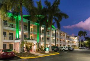 a hotel with cars parked in a parking lot at HomeTowne Studios by Red Roof Fort Lauderdale in Fort Lauderdale