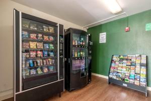 two soda machines are in a room with green walls at HomeTowne Studios by Red Roof Fort Lauderdale in Fort Lauderdale