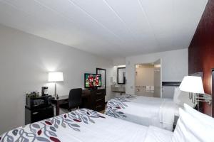 a hotel room with two beds and a desk and a television at Red Roof Inn Danville, PA in Danville