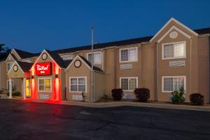 un hotel con un letrero de neón rojo delante de él en Red Roof Inn Springfield, MO en Springfield