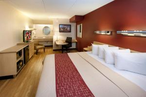 a hotel room with a large bed and a desk at Red Roof Inn Harrisburg - Hershey in Harrisburg
