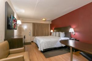 a hotel room with a bed and a desk at Red Roof Inn PLUS+ Columbus - Dublin in Dublin