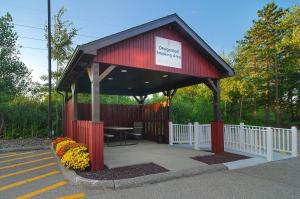 a red pavilion with a table and a white fence at Red Roof Inn Erie – I-90 in Erie