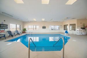 una piscina en una habitación grande con sillas y mesas en Red Roof Inn St Louis - Troy, IL, en Troy