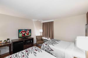 a hotel room with two beds and a flat screen tv at Red Roof Inn Roanoke Rapids in Roanoke Rapids