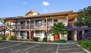 a large apartment building with a parking lot at Red Roof Inn Lompoc in Lompoc