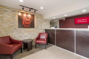 a bar in a restaurant with two red chairs at Red Roof Inn Fort Worth South in Fort Worth