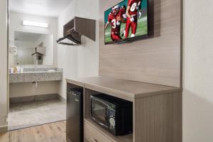 a kitchen with a microwave and a tv on the wall at Red Roof Inn Fort Worth South in Fort Worth