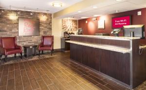 a waiting room at a fast food restaurant with red chairs at Red Roof Inn Detroit - Royal Oak/Madison Heights in Madison Heights