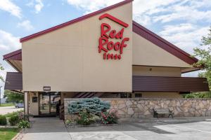 una señal roja de la posada en el lateral de un edificio en Red Roof Inn Lafayette - Purdue University, en Lafayette