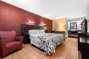 ein Hotelzimmer mit einem Bett und einem Stuhl in der Unterkunft Red Roof Inn Lafayette - Purdue University in Lafayette