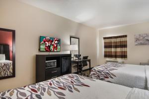 a hotel room with two beds and a flat screen tv at Red Roof Inn Fort Worth - Saginaw in Fort Worth