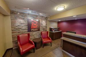 a waiting room with two red chairs and a bar at Red Roof Inn PLUS+ University at Buffalo - Amherst in Amherst