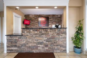 a brick wall in a lobby with a red neon sign at Red Roof Inn Knoxville North - Merchants Drive in Knoxville +22 photos