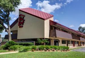 a front view of a hotel with a red roof at Red Roof Inn Pensacola - I-10 at Davis Highway in Pensacola