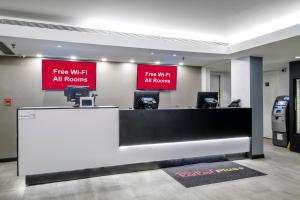 un ufficio con due cartelli che dicono wifi gratuito in tutte le camere di Red Roof Inn PLUS Orlando-Convention Center- Int'l Dr a Orlando
