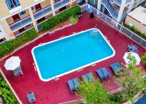 
a pool with a pool table and chairs in it at Red Roof Inn PLUS+ Orlando - Convention Center / Int'l Dr in Orlando
