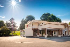 un gran edificio blanco con el sol en el cielo en Red Roof Inn Abingdon, en Abingdon