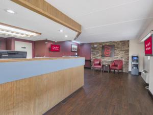 a lobby with a bar and red chairs at Red Roof Inn Atlanta-Norcross in Norcross