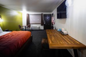 um quarto com uma cama e uma mesa de madeira em Campfire Hotel em Bend