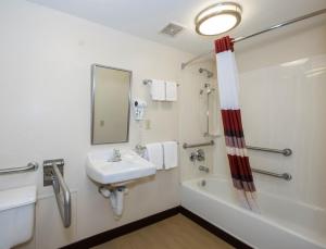 a bathroom with a sink and a bath tub at Red Roof Inn Milford - New Haven in Milford